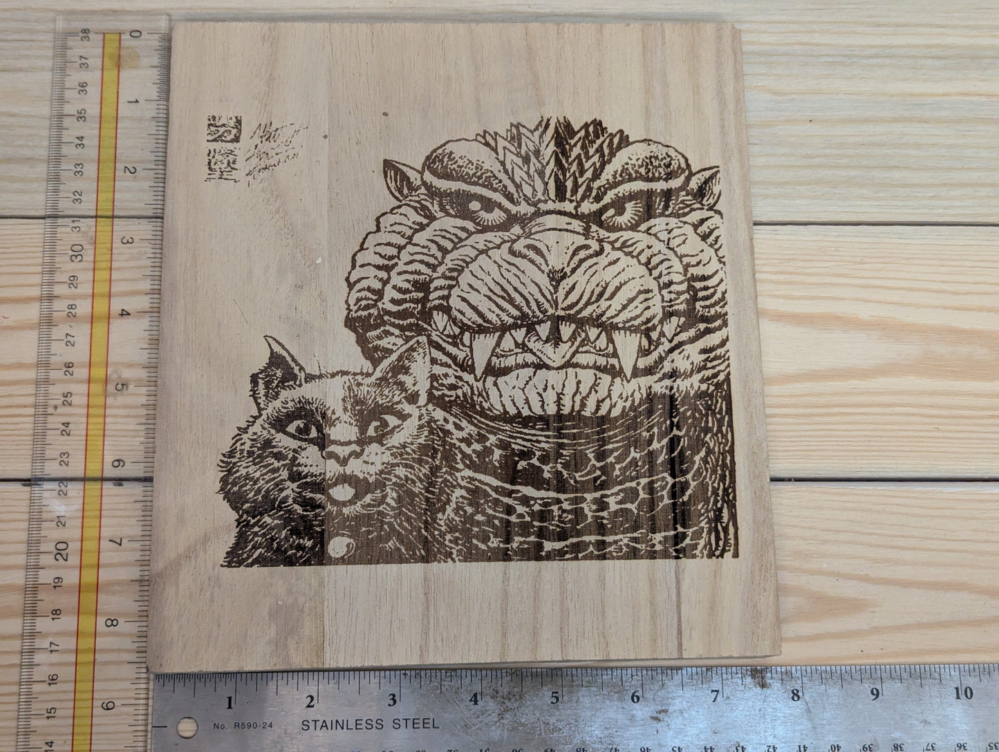 Wood etched cat and Godzilla